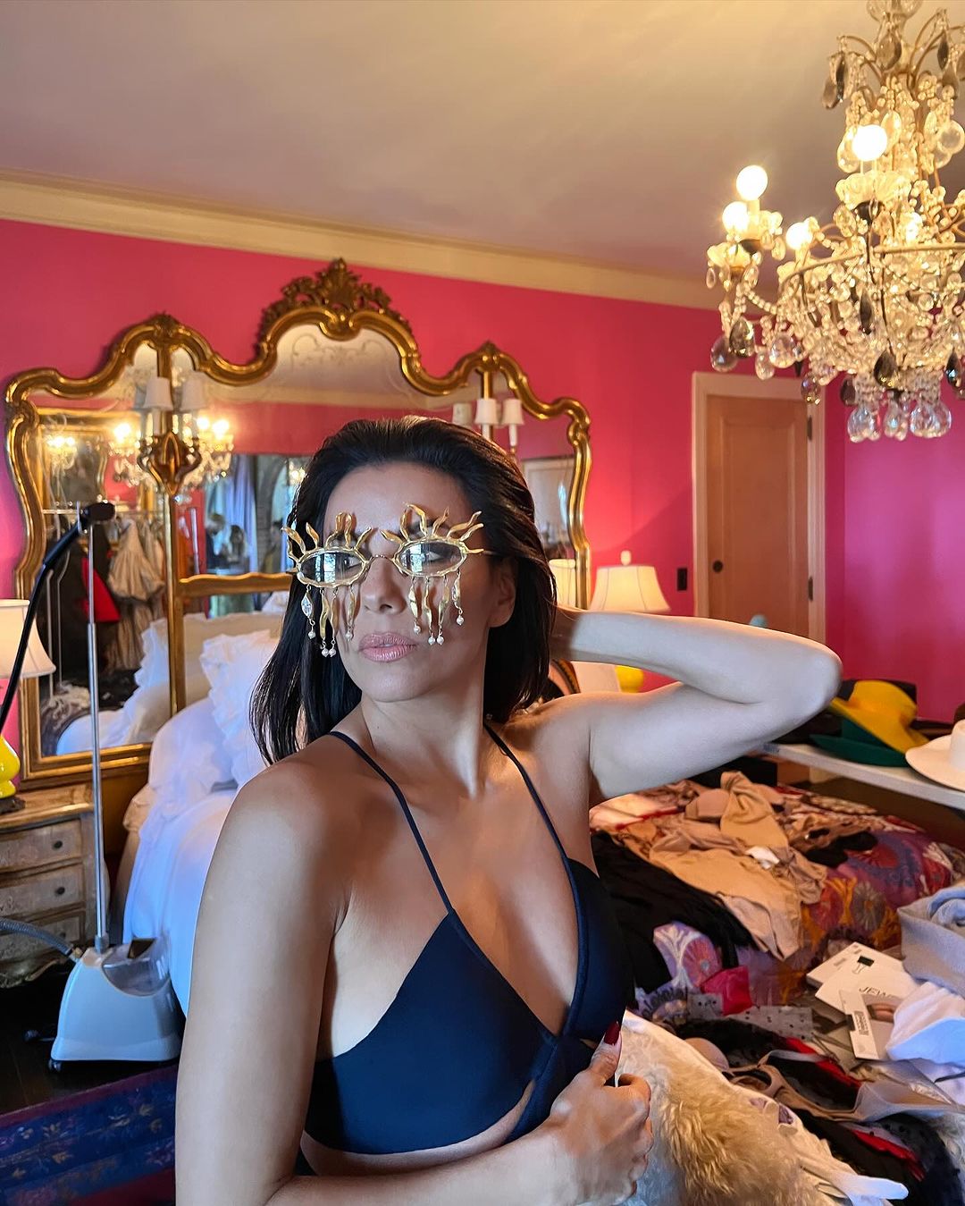 The star was surrounded by clothes and clutter as she posed in a plunging dress and high-fashion glasses