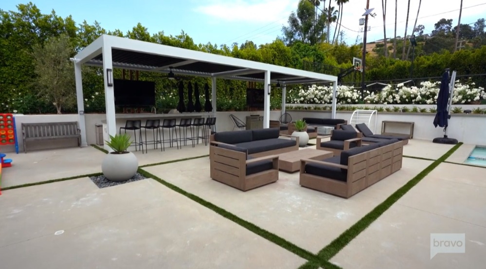 There is a space for relaxation on comfy couches that's next to the outdoor kitchen