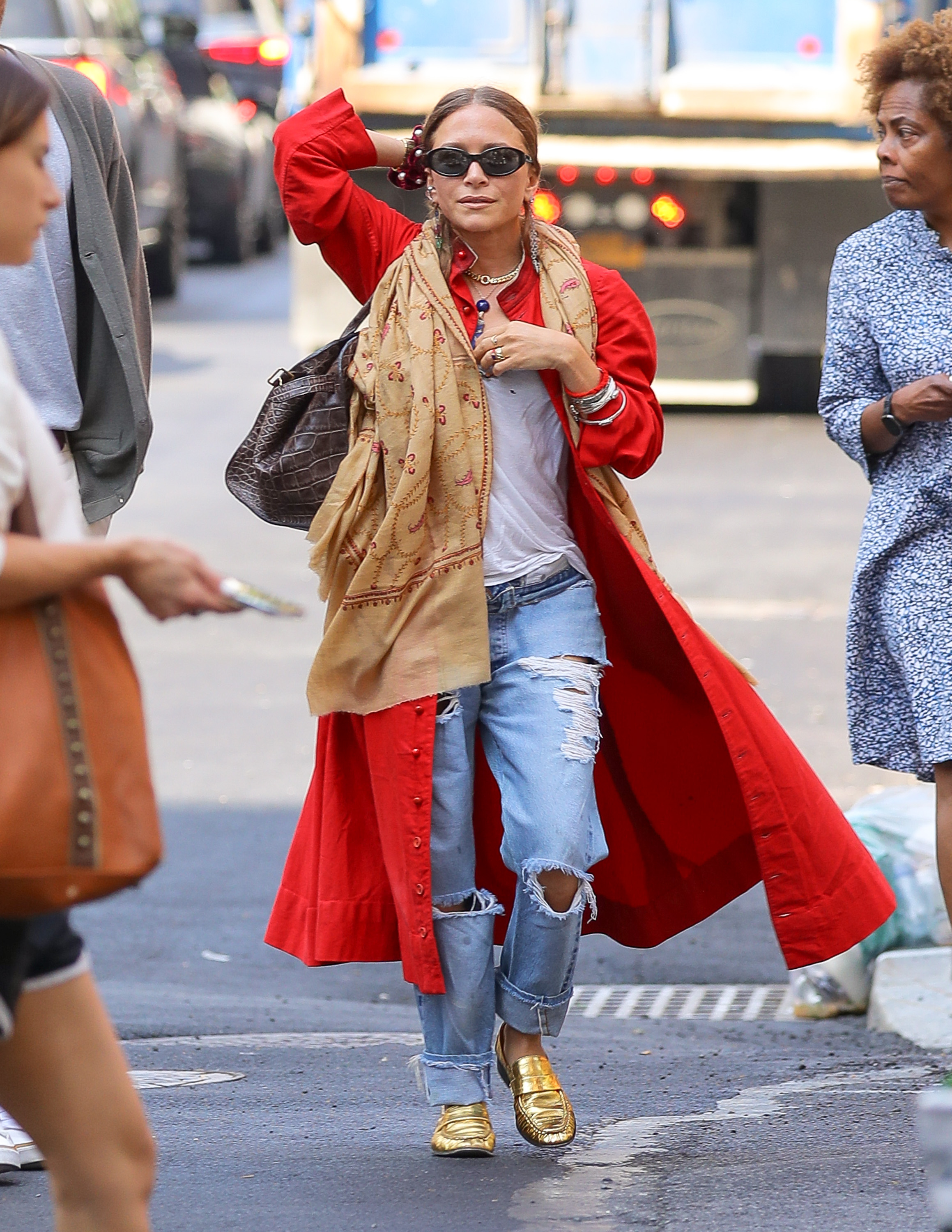 Mary-Kate wore ripped jeans with a red trench coat during her New York outing over the summer