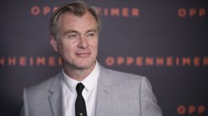 christopher nolan in a gray suit and black tie