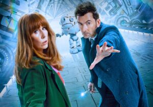 The Fourteenth Doctor poses with his sonic screwdriver beside Donna Noble with a clunky robot behind them in promo art for “Wild Blue Yonder.”
