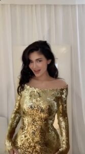 Kylie Jenner showed off her shrinking waist in a tight gold gown while attending her family's lavish Christmas Eve party