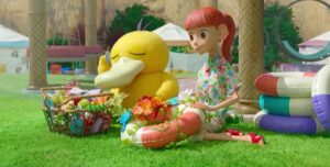 A still from the stop-animation show Pokemon Concierge. It shows Haru and Pysduck sitting outside and decorating floaties. The Pysduck is closing its eyes and trying to listen to a sound in the shell.