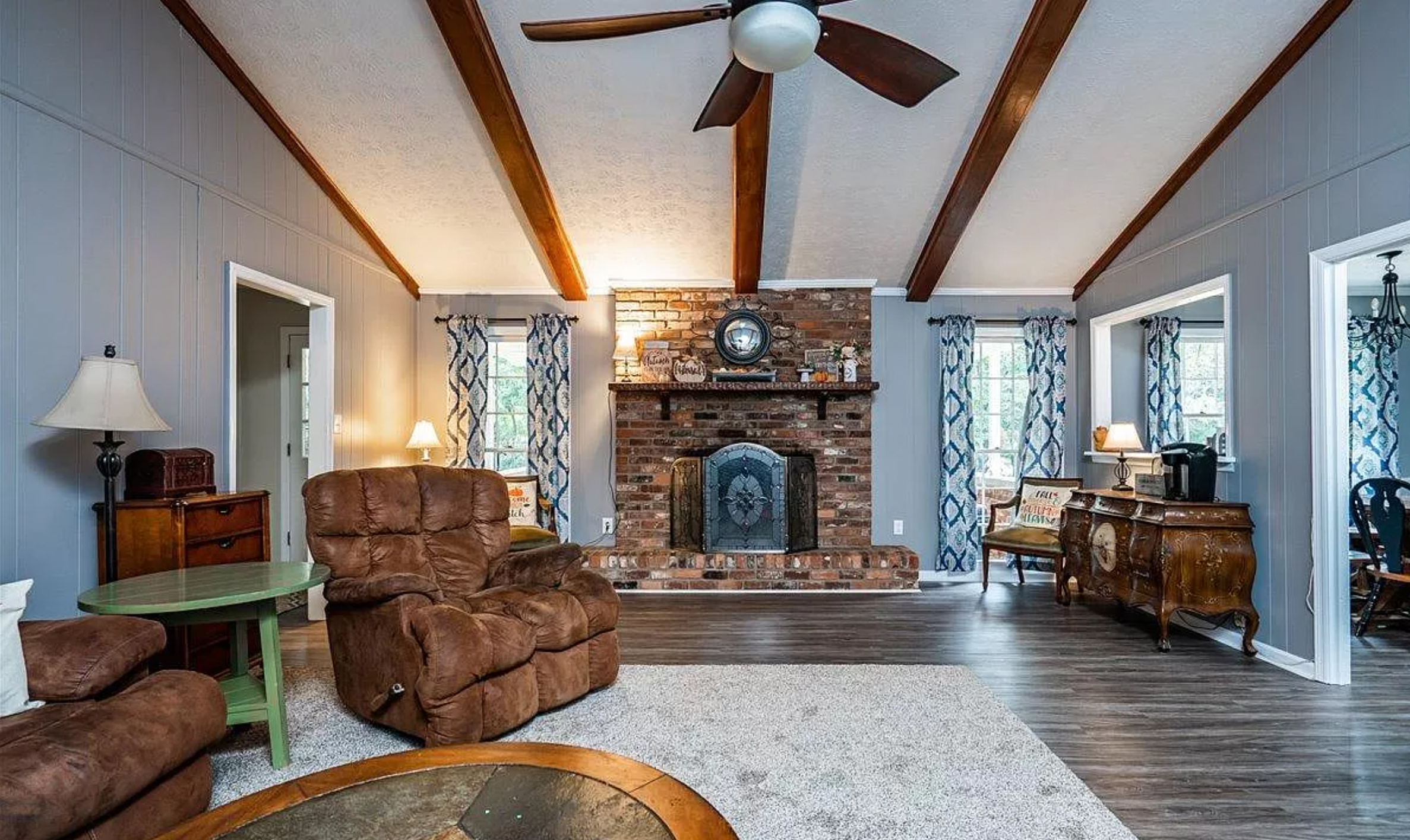 Her home has a brick fireplace and wood beams in the living room
