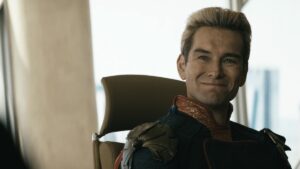 Homelander gives a creepy smile at a shareholder's meeting on The Boys in Prime Video ad and price increase article.