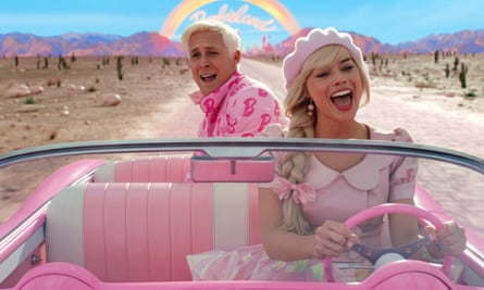 Two white blond people in a pink car, wearing pink clothes, driving through a fake desert landscape with a rainbow in the background.