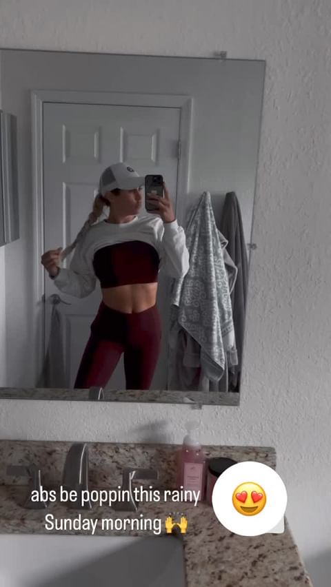 The influencer pulled up her sweater to reveal her sports bra and 'poppin' abs