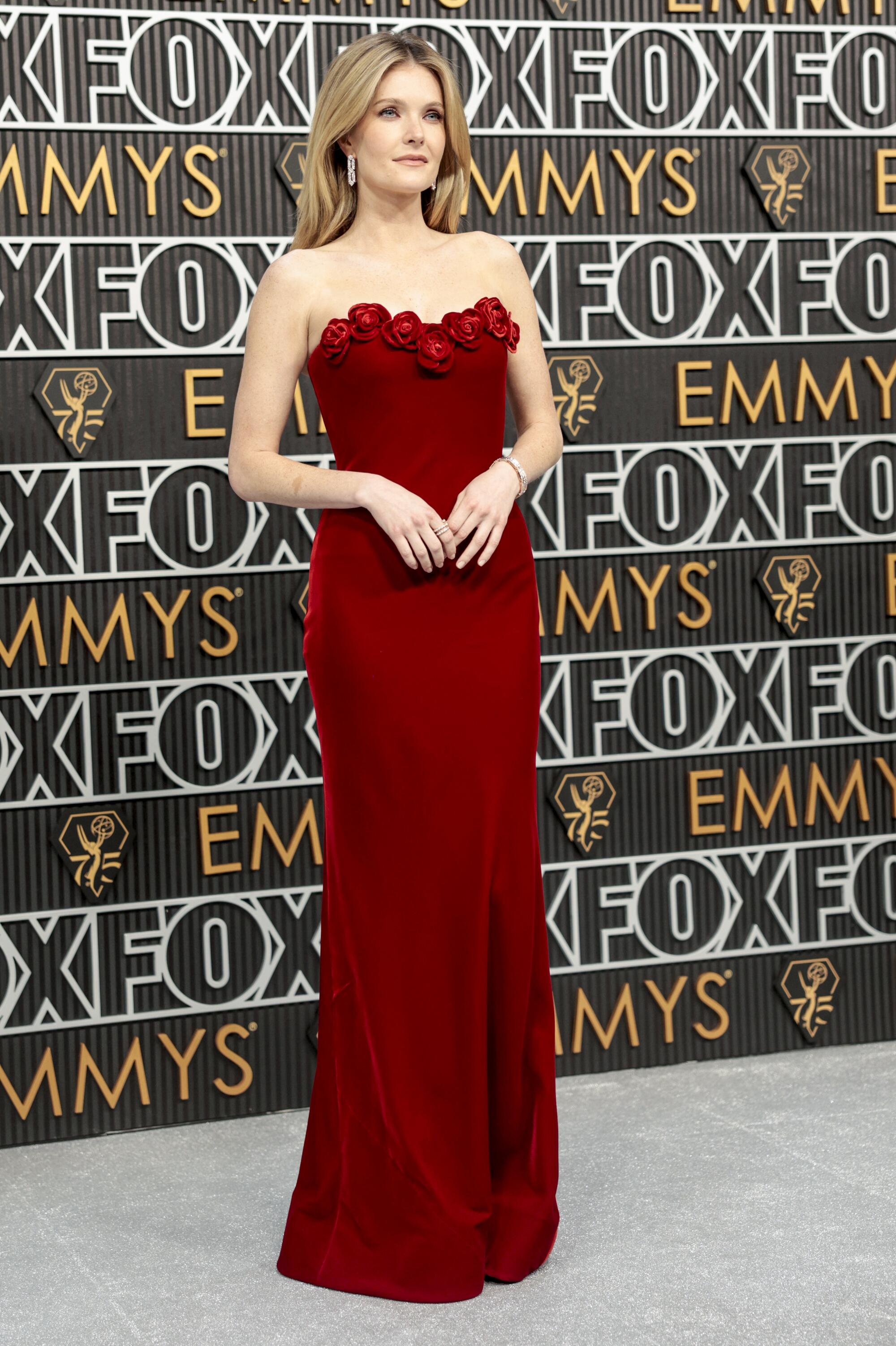 Meghann Fahy wears a red dress on the Emmys red carpet. 