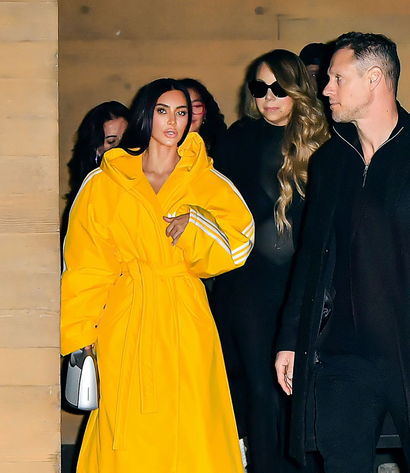 Kim wore a loose-fitting yellow jacket while walking next to pop legend Mariah Carey