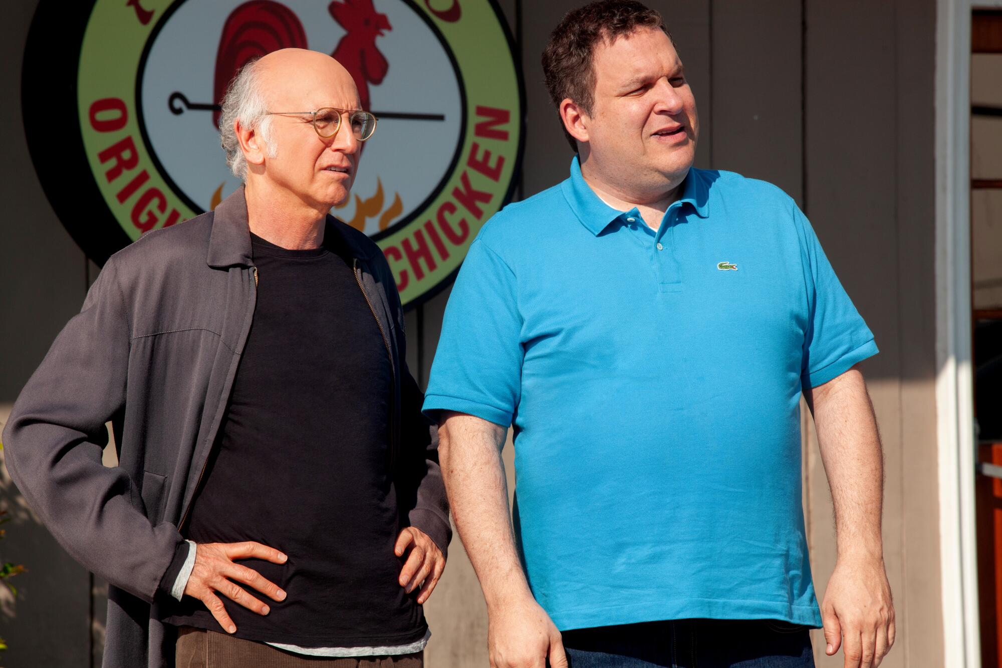 Two men stand outside a chicken restaurant