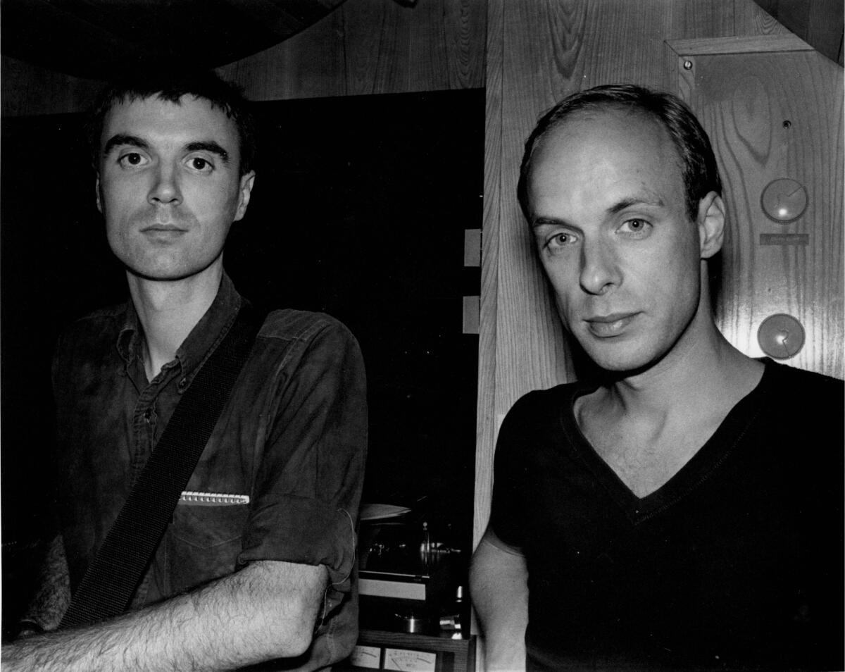 Two men pose for a photo in a recording studio.