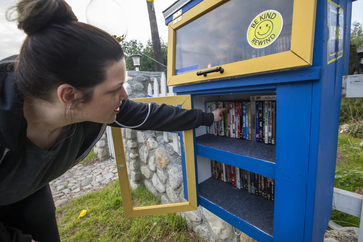 A woman checks out DVDs for rent for free.