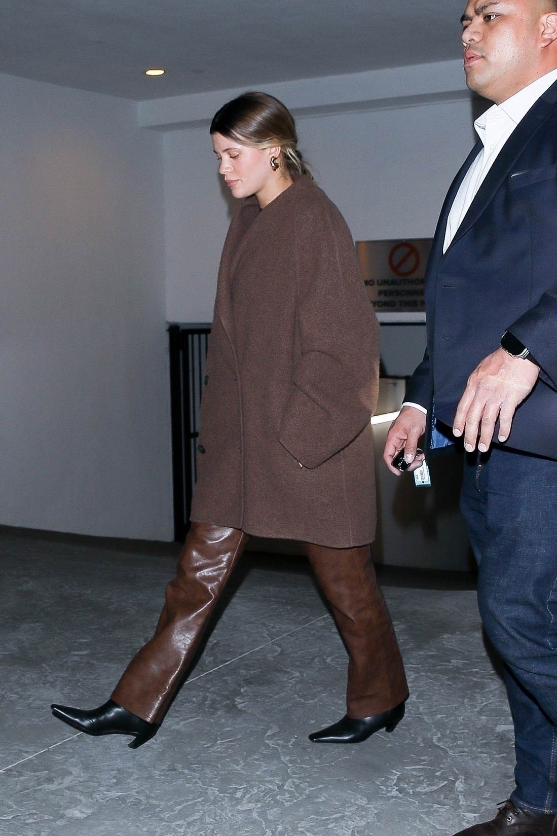 She paired the jacket with brown leather pants and black, short-heeled boots