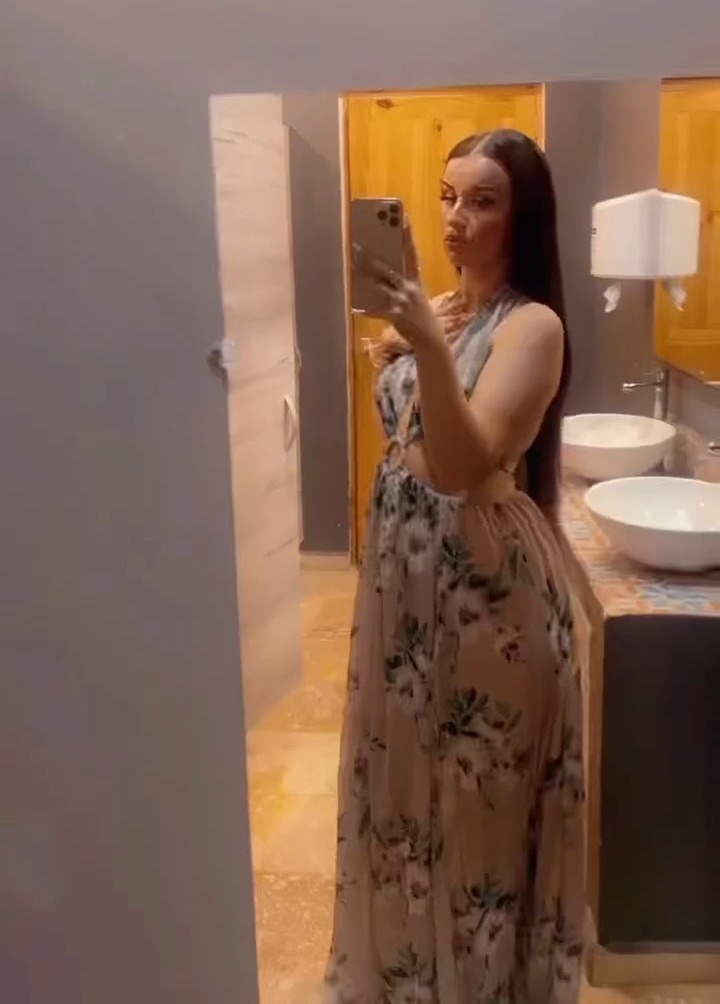 Kayla captured a side view of herself through a bathroom mirror, with the dress draped over her stomach