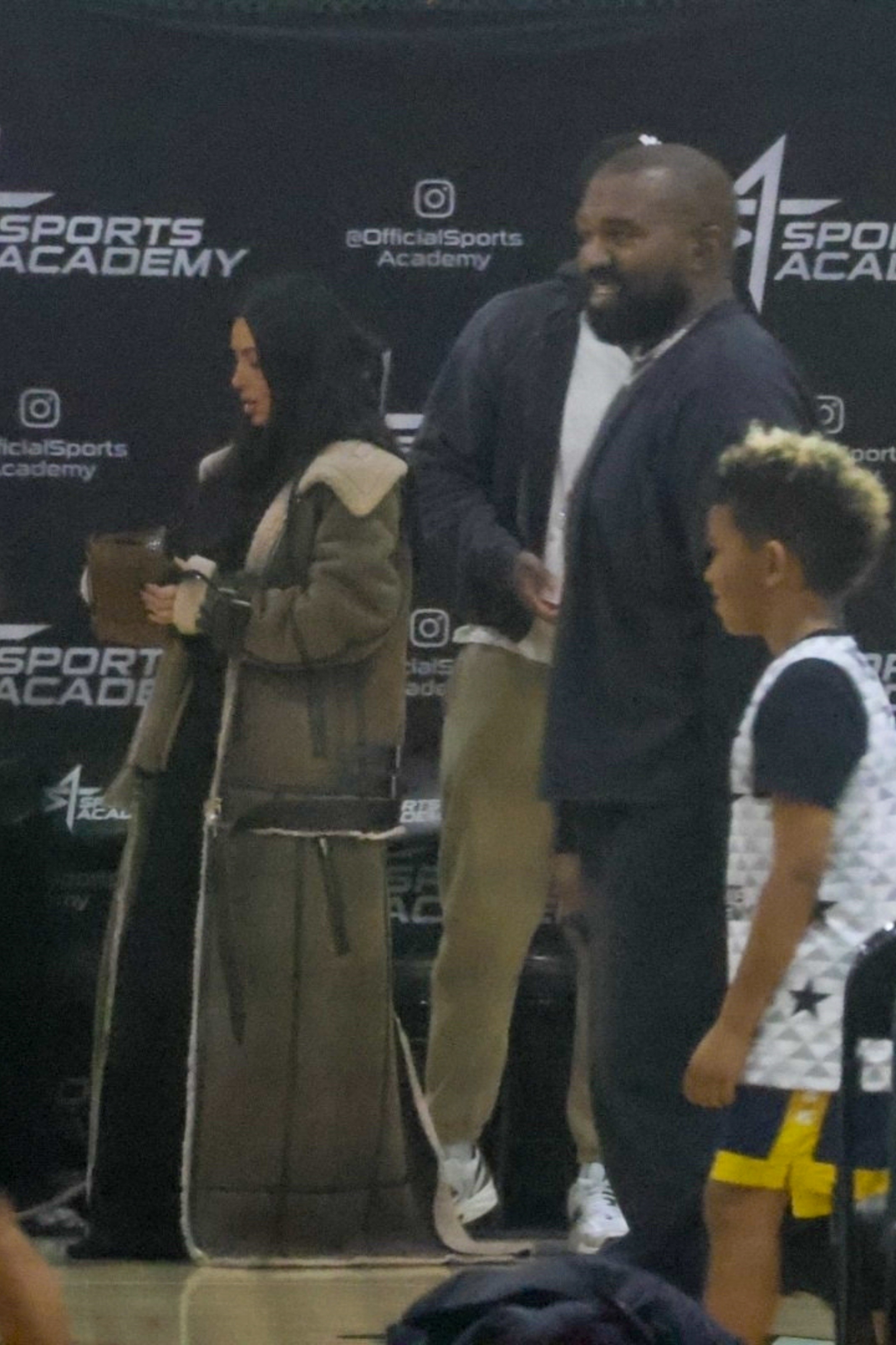 Kim looked less animated than Kanye as they supported their son Saint (right)