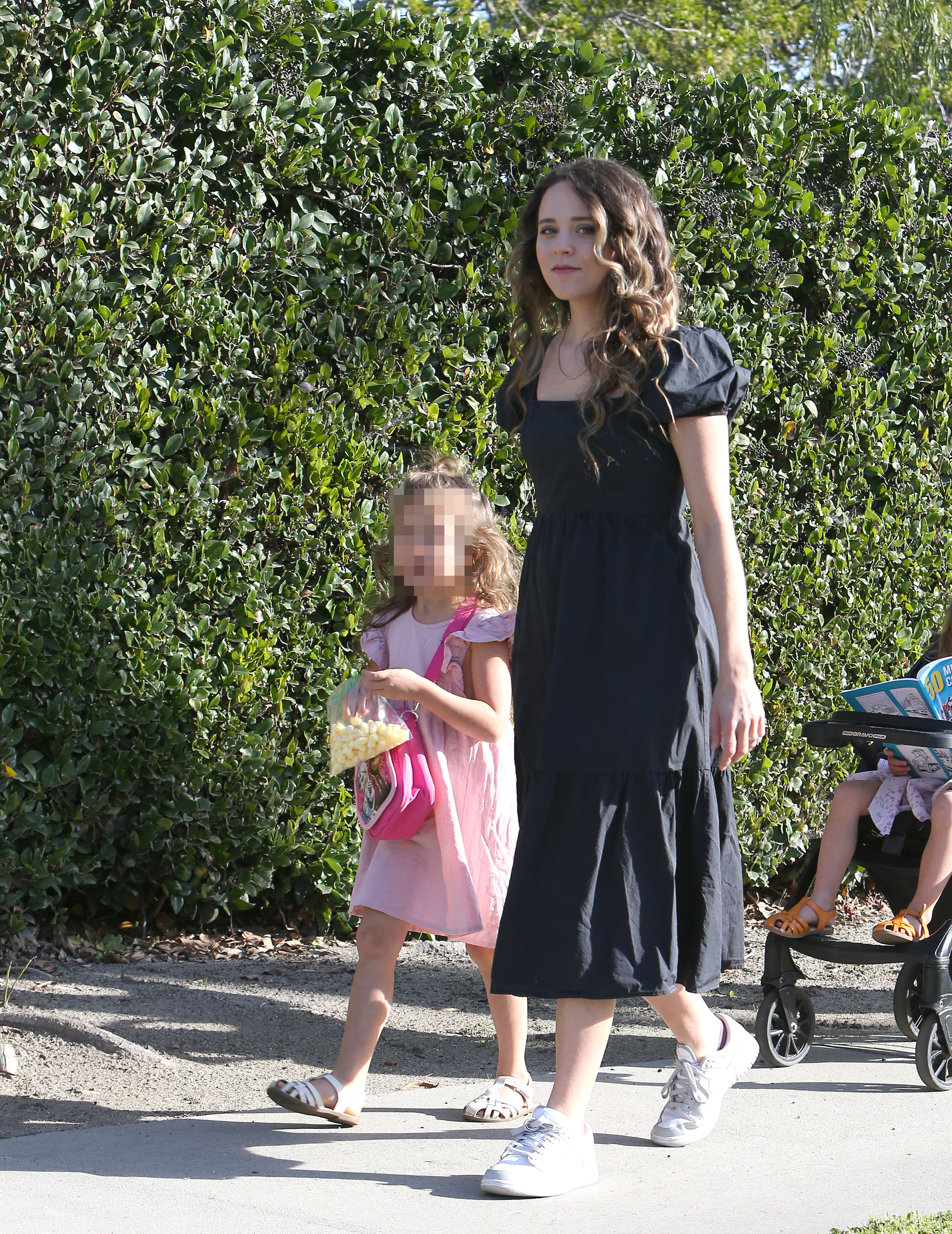 Jinger donned a loose-fitting black dress that fell well below her knees as she walked around her Los Angeles neighborhood with her husband and their kids