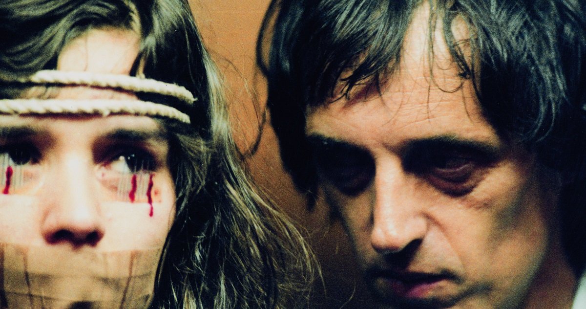 Dario Argento looms over actress Cristina Marsillach, tied up with needles taped to her eyelids, while filming Opera.