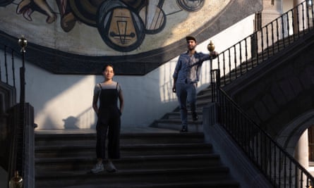 Paola Vera and Pedro Álvarez-Luna stand on the stairs of the Secretary of Public Education building in front of a mural