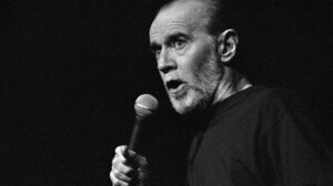 george carlin speaking into a microphone