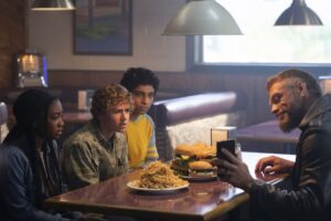 Annabeth, Percy, and Grover getting cheeseburgers with Ares in a dingy roadside diner