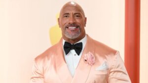the rock in a salmon colored suit at the academy awards