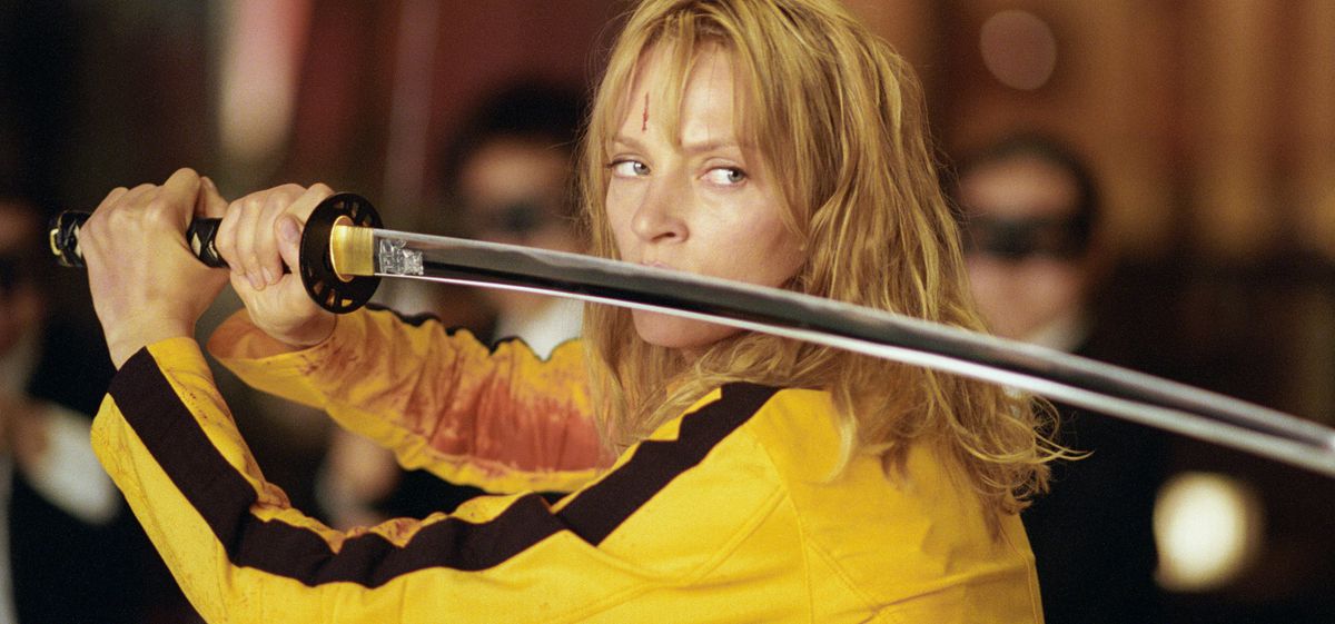 Dressed in a yellow jumpsuit, Beatrix poses with her sword in Kill Bill: Volume 1