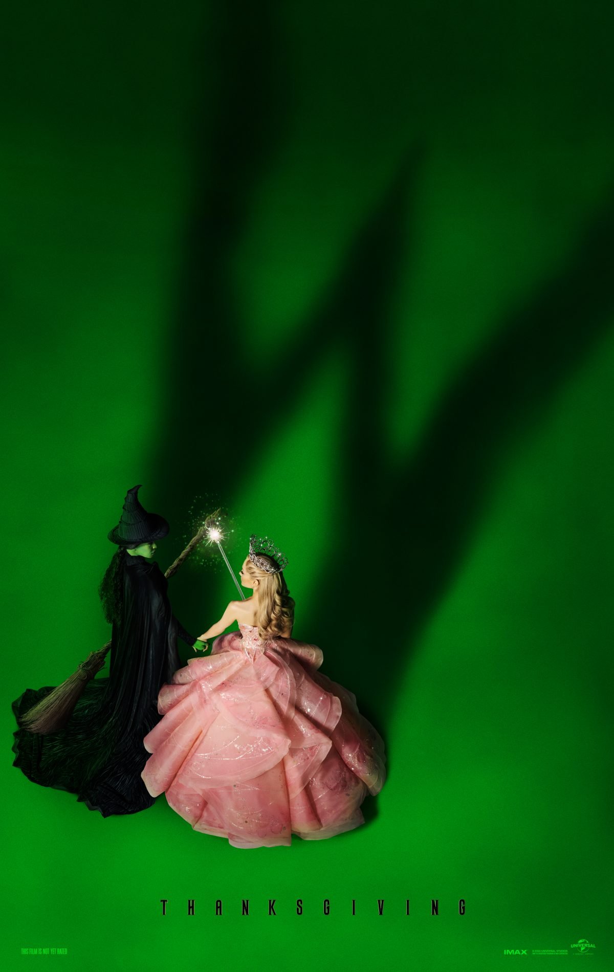 Elphaba and Glinda on a green background in the poster for Wicked, released with the Wicked trailer