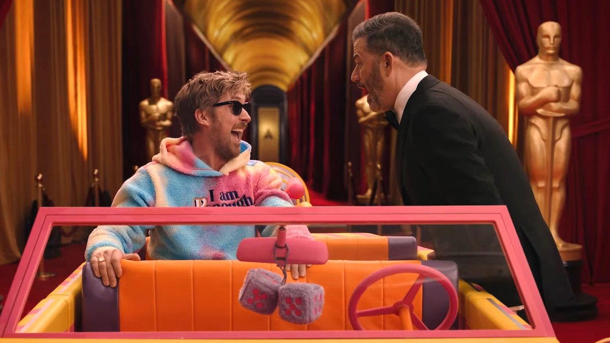 Ryan Gosling in his Barbie Kenough sweatshirt screams along with a tuxedo-wearing Jimmy Kimmel near giant Oscar statues