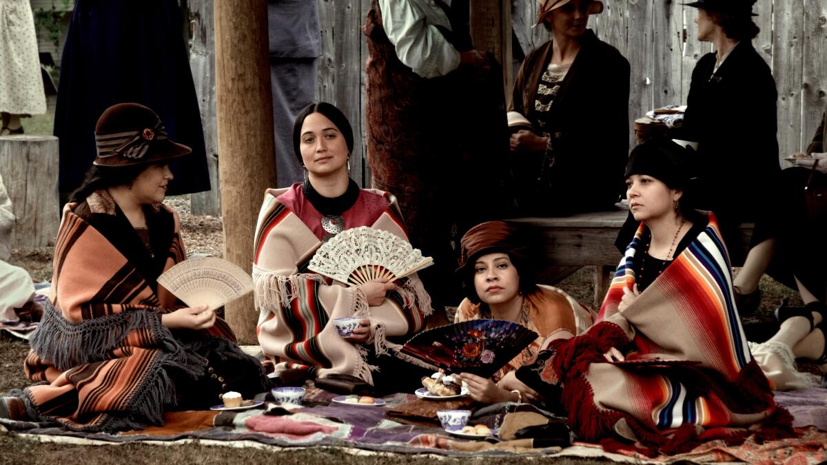 Osage women sit together and chat at a picnic in "Killers of the Flower Moon."
