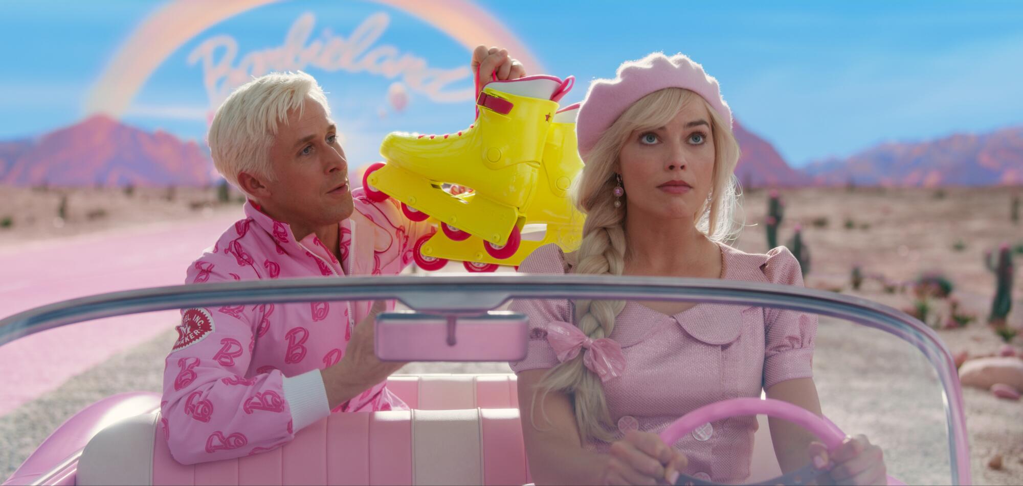 Ryan Gosling and Margot Robbie drive through the desert in a pink convertible in "Barbie."