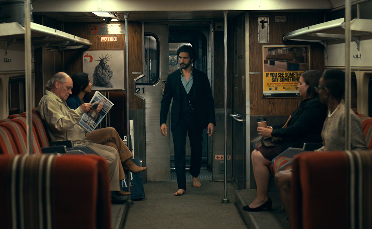 Ezekiel Sims (Tahar Rahim) stalks through a New York City subway car, wearing a suit, a blue shirt, and no shoes (ew, on the SUBWAY?!) in Madame Web
