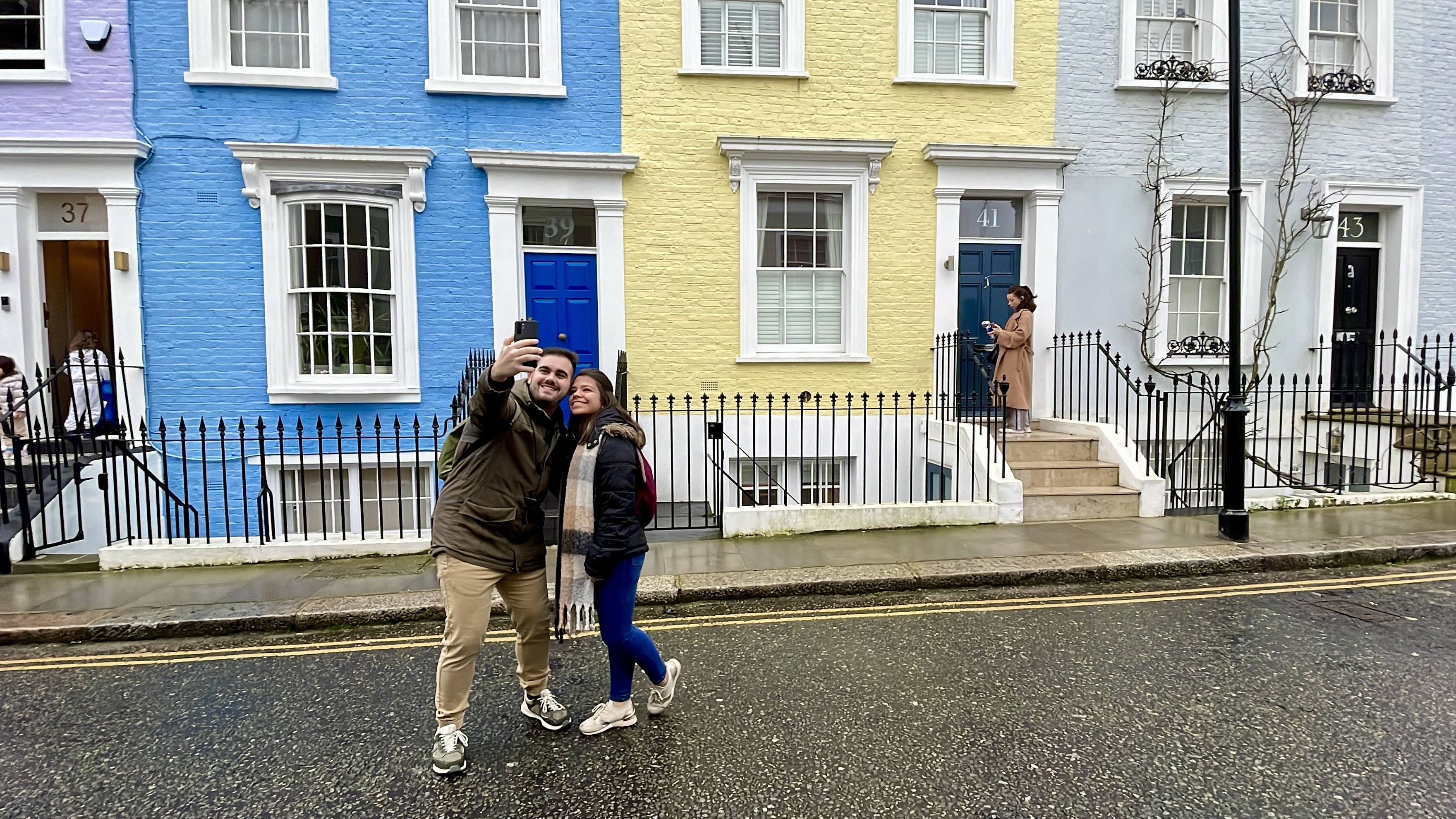 Goncalo (left) and Ana (right) from Portugal snap a photo in front of the Hillgate Village homes