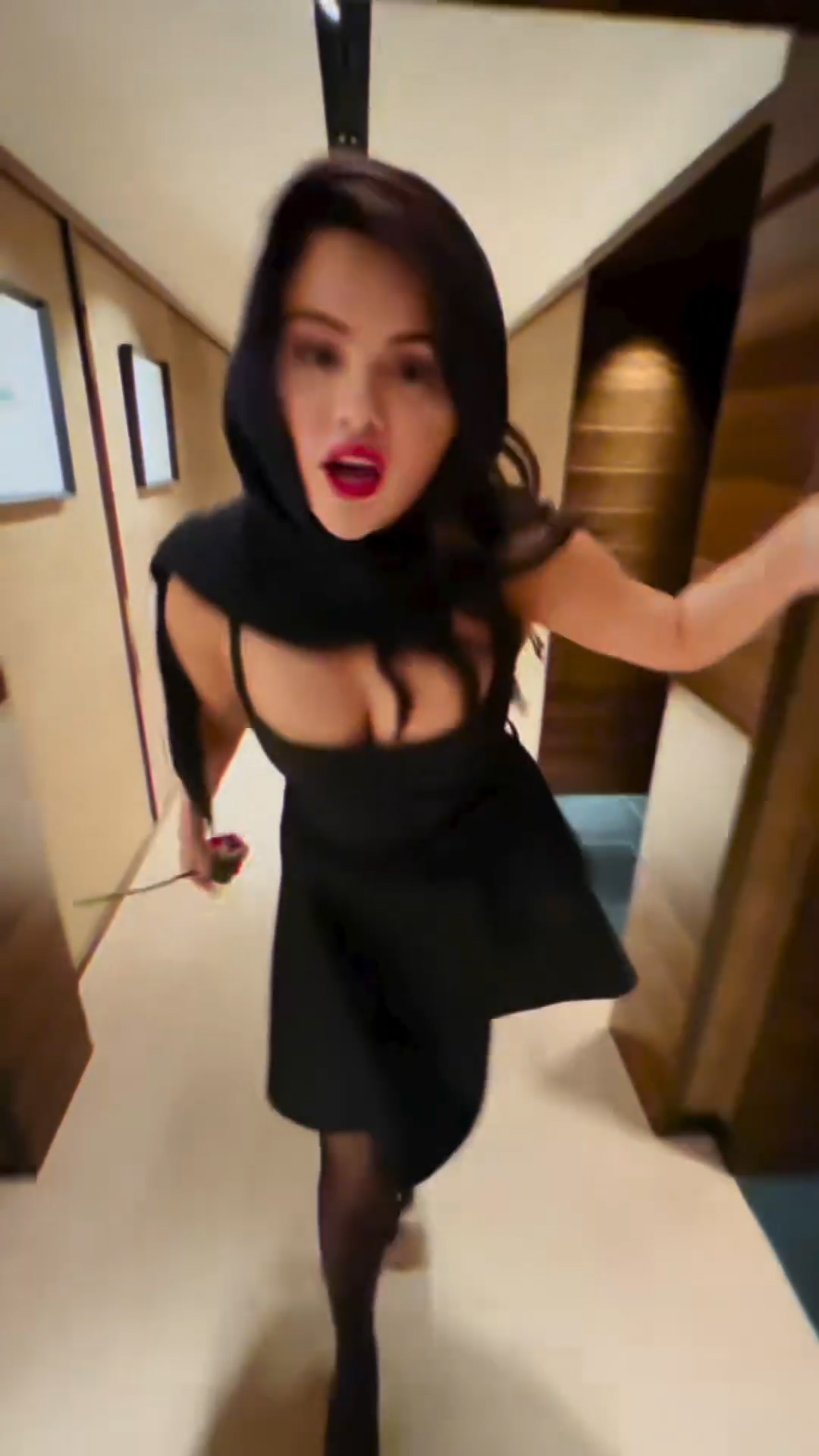 Selena wore a black dress as she walked across the hallways