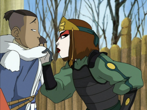 Sokka tied up while Suki grabs him by his cowl and gets in his face