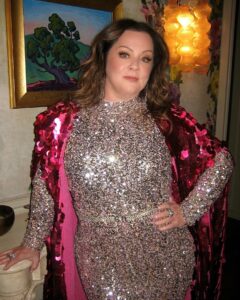 Melissa McCarthy flaunted her slimmer figure in a skintight catsuit fully composed of sequins and a hot pink cape