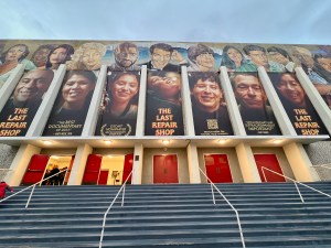 The Hollywood High School auditorium exterior with banners featuring the cast of 'The Last Repair Shop'