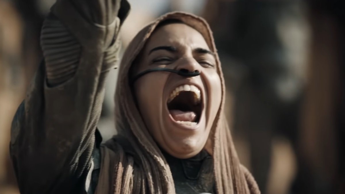 A Fremen woman screaming in joy with her arm raised in Dune: Part Two