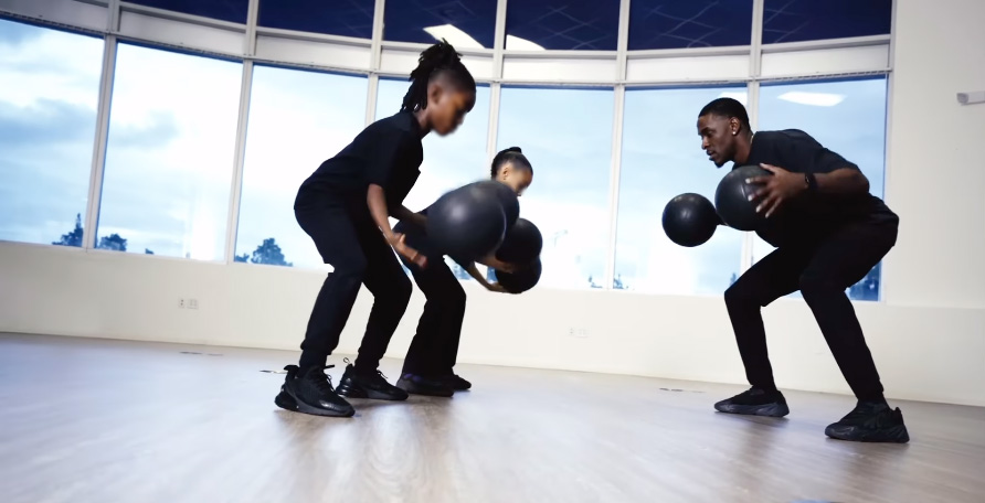 Children can be seen learning basketball choreography and wearing all-black outfits