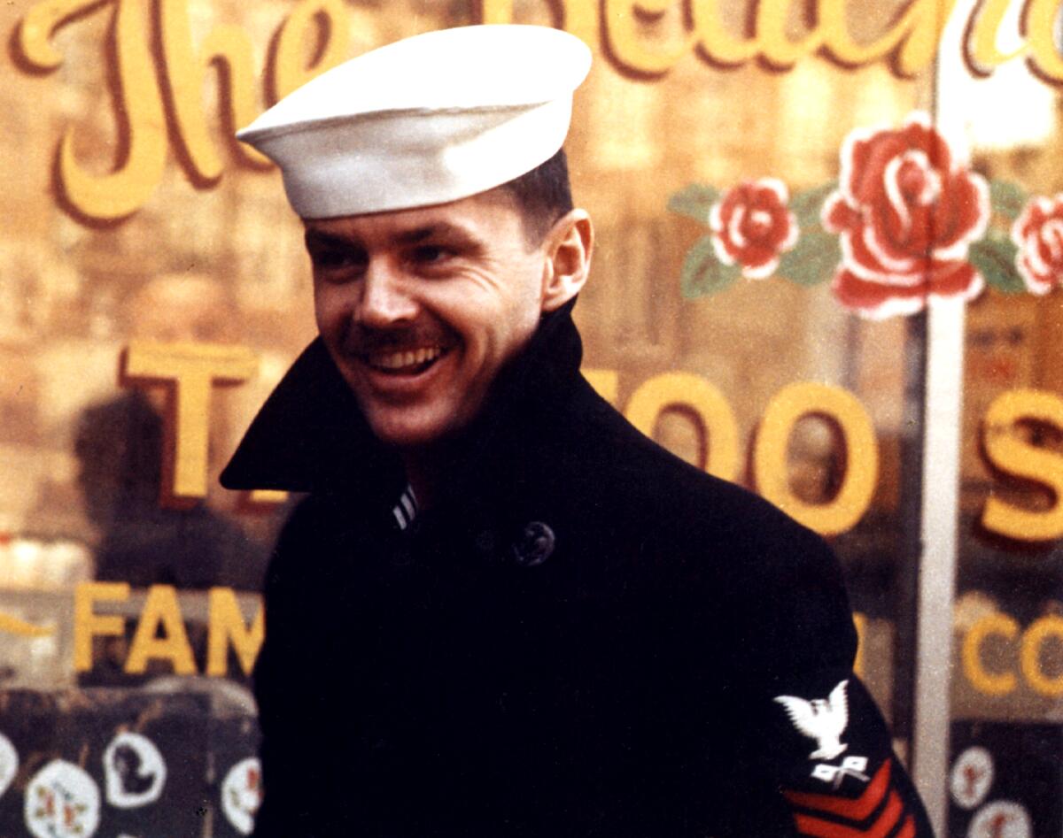 A man in a sailor cap smiles.