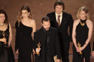 "20 Days in Mariupol" direector Mstyslav Chernov, center, accepting the Oscar for documentary feature at 96th Academy Awards.