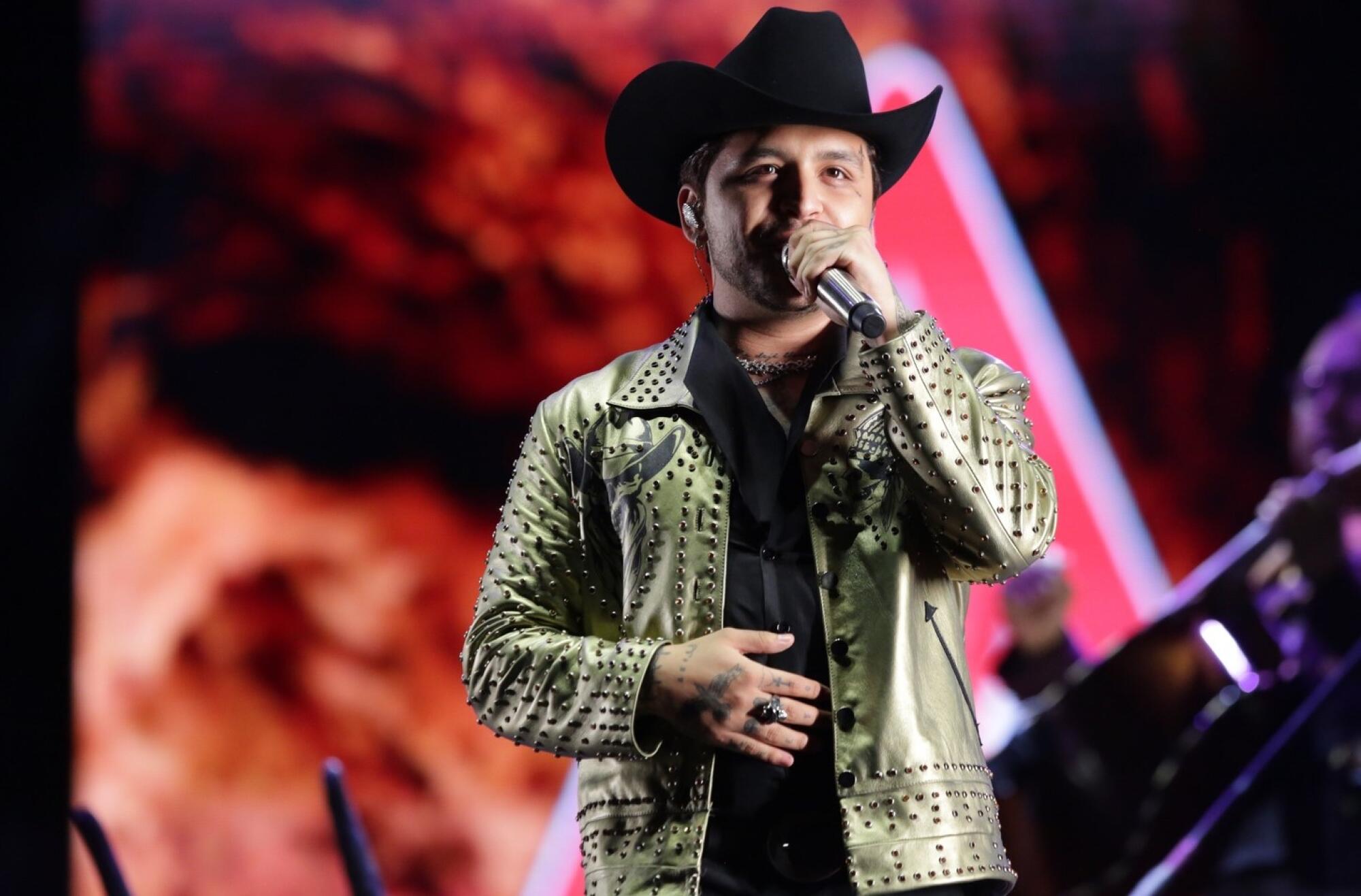 Christian Nodal performs in a black cowboy hat.