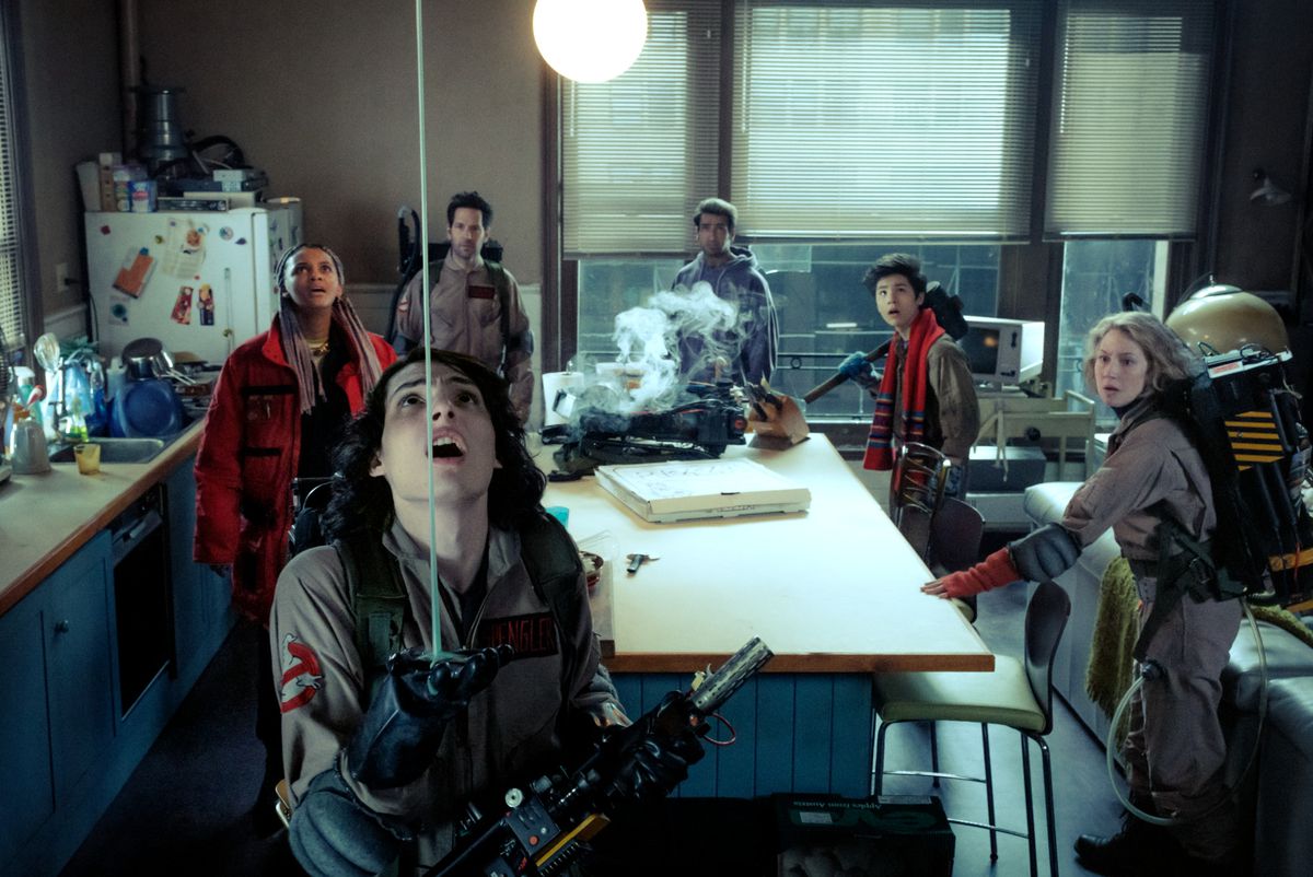 Finn Wolfhard in a Ghostbusters uniform looking at slime coming from the ceiling while Kamail Nanjiani, Logan Kim, Paul Rudd, and Celeste O’Connor stand behind him in Ghostbusters: Frozen Empire