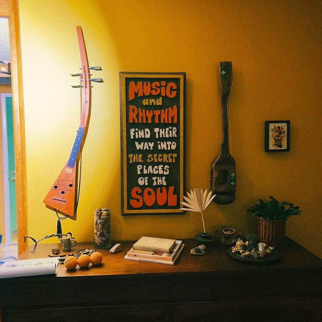 Gwen shared a photo of a desk surrounded by guitars, a small painting, and poster