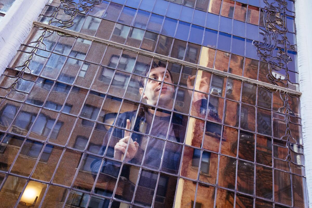 A man photographed through a gridded window.