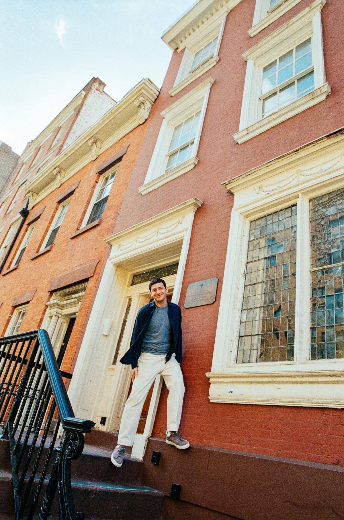 A man in front of a brick building.