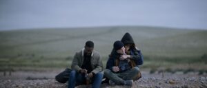 Jovan Adepo as Saul Durand, Alex Sharp as Will Downing, Eiza González as Auggie Salazar on a beach in a still from 3 Body Problem