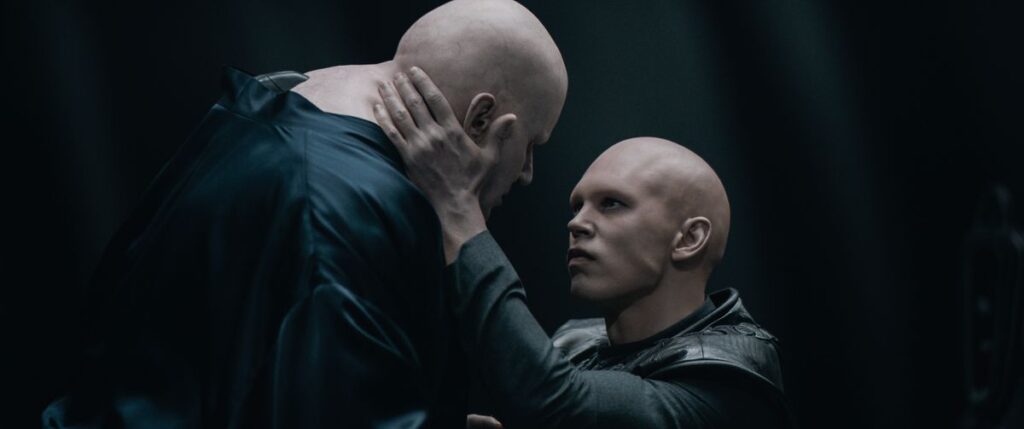 Austin Butler cradles Stellan Skarsgard’s head and stares into his eyes in Dune: Part Two. Both are completely bald