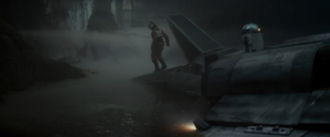 Luke Skywalker stands on his half-sunken x-wing fighter in the swamp of Dagobah.