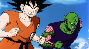 Goku and a sweating Piccolo stand side by side to battle a common foe, both baring their teeth to show they’re ready to fight in Dragon Ball Z