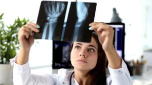Woman doctor looking at x-ray of hand
